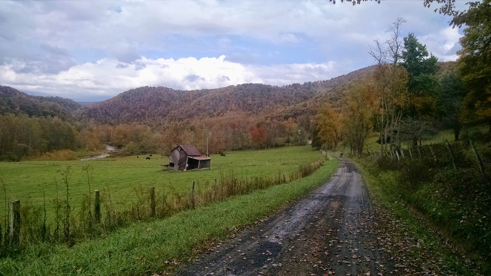 The farmhouse and white barn down a country road, with the mountains beyond — Dry Fork, West Virginia